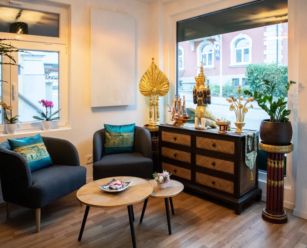 Wartebereich mit Sesseln und goldenen Figuren